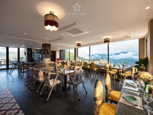 a restaurant with tables and chairs and large windows at Azalea Sapa Hotel in Sa Pa