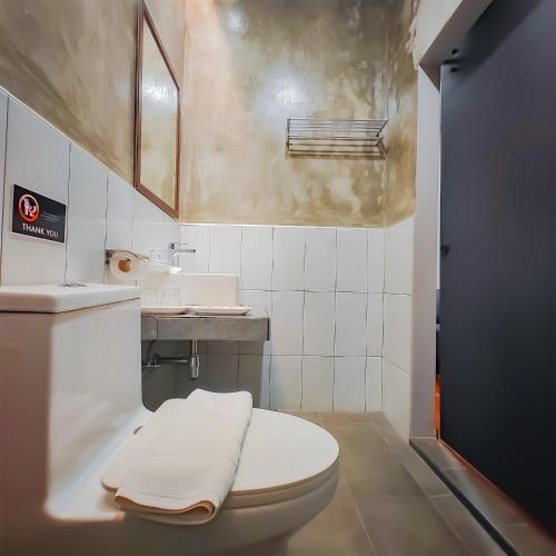 a bathroom with a white toilet and a sink at The Riva Vientiane Hotel in Vientiane