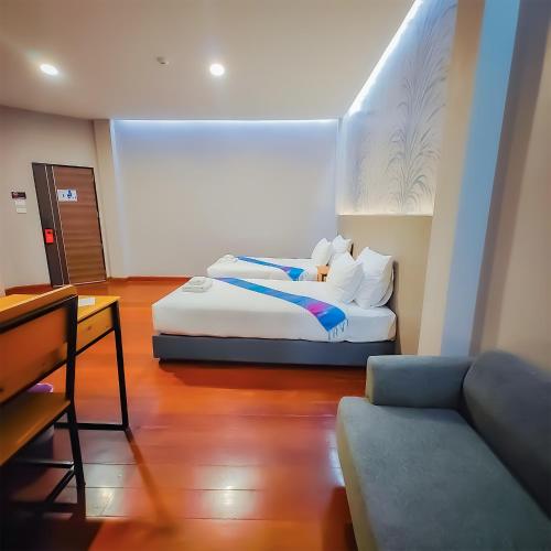 a room with two beds and a couch in it at The Riva Vientiane Hotel in Vientiane