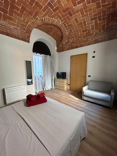 a bedroom with a large white bed with a brick ceiling at Civico 11 in Alba