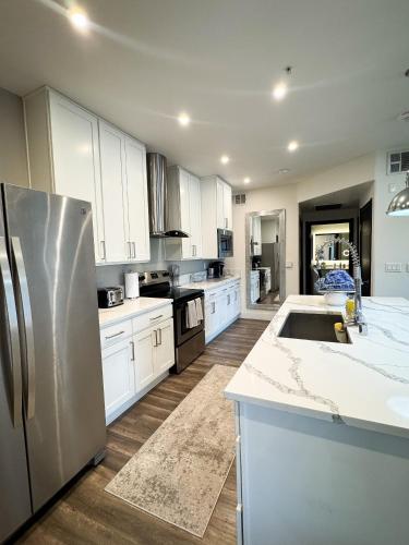 a kitchen with white cabinets and a stainless steel refrigerator at Rest Away in Las Vegas