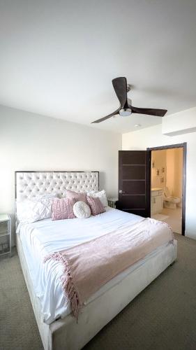 a bedroom with a large white bed with a ceiling fan at Rest Away in Las Vegas