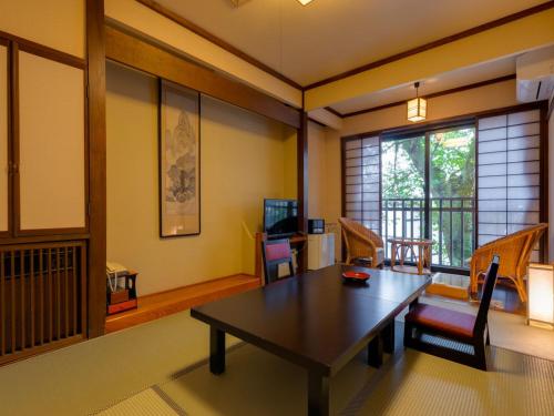a room with a table and chairs and a window at Otowaya Ryokan in Yuzawa