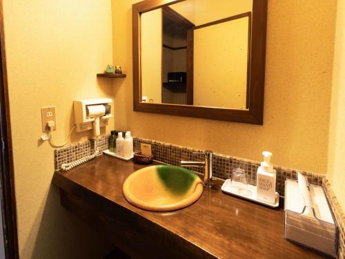 a bathroom with a sink and a mirror at Otowaya Ryokan in Yuzawa
