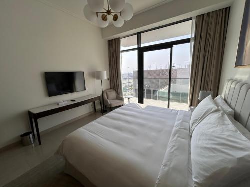 a bedroom with a white bed and a large window at Address Residence Bahrain in Rayyā