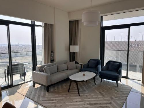 a living room with a couch and two chairs and a table at Address Residence Bahrain in Rayyā