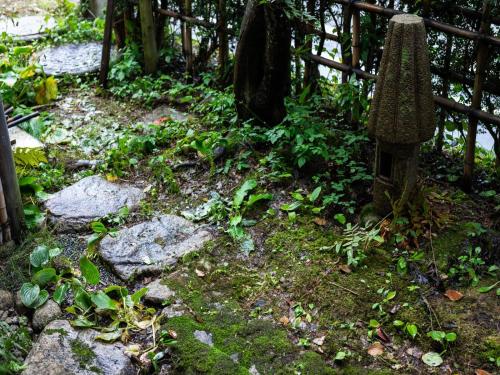 a garden with rocks and plants and a fence at Otowaya Ryokan in Yuzawa