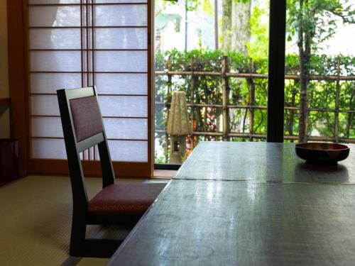a wooden table with a chair and a bowl on top at Otowaya Ryokan in Yuzawa