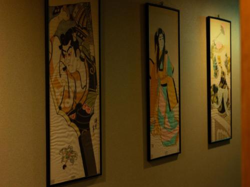 four pictures of women are hanging on a wall at Otowaya Ryokan in Yuzawa
