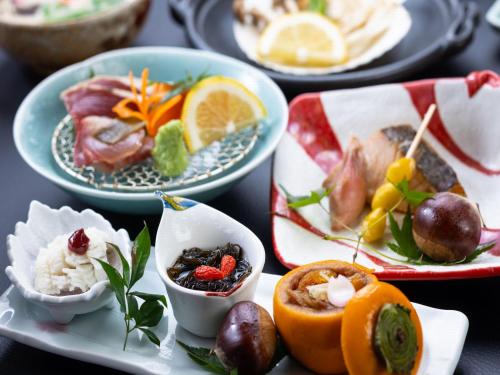 a table topped with plates of food with fruits and vegetables at Otowaya Ryokan in Yuzawa