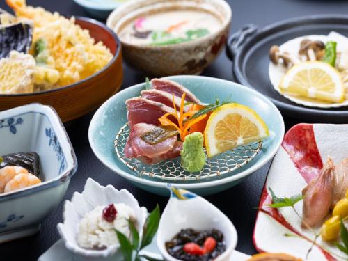 a table topped with bowls of different types of food at Otowaya Ryokan in Yuzawa