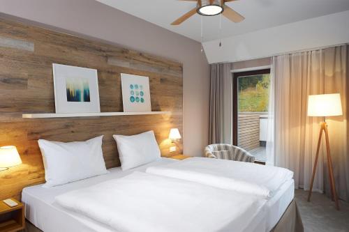 a bedroom with a large white bed and a window at Cihelny Golf & Wellness Resort in Karlovy Vary