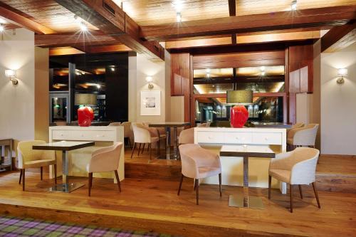 a dining room with tables and chairs and wooden ceilings at Cihelny Golf & Wellness Resort in Karlovy Vary