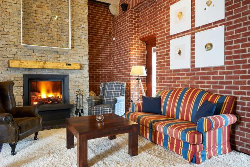 a living room with a couch and a fireplace at Cihelny Golf & Wellness Resort in Karlovy Vary