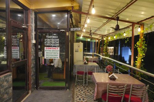 a restaurant with tables and chairs on a balcony at Sea Pearl Homestay in Port Blair