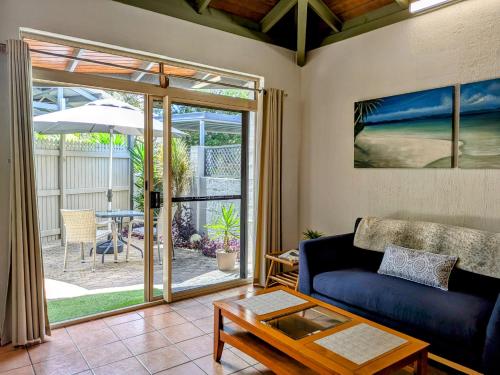 a living room with a couch and a table at Beachside Cottage - A Private Peaceful Hidden Gem 50m to Beach in Nelly Bay