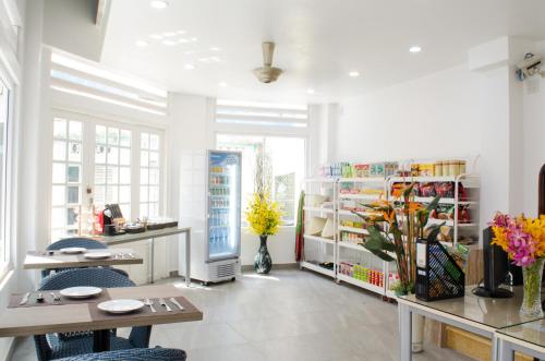 a white room with a table and chairs and flowers at LeBlanc Saigon in Ho Chi Minh City
