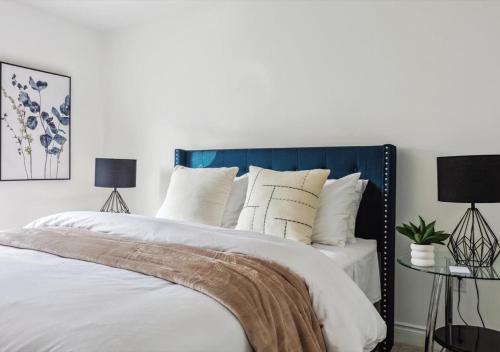 a bedroom with a bed with a blue headboard and pillows at Luxurious and Beautiful, Barrie in Barrie
