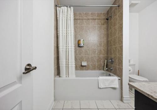 a bathroom with a bath tub and a toilet at Luxurious and Beautiful, Barrie in Barrie