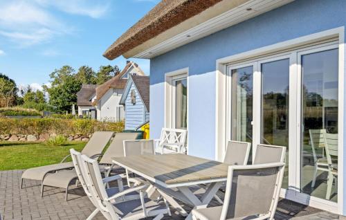 a patio with a wooden table and chairs at Nice Home In Glowe With Wifi in Glowe