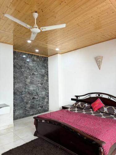 a bedroom with a bed and a ceiling fan at The Ivyview Villa Kumarhatti Barog Near Kasauli in Barog