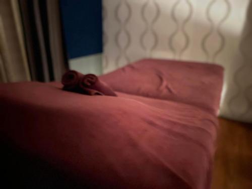a close up of a bed with a red blanket at Regalodge Hotel & Spa Ipoh in Ipoh