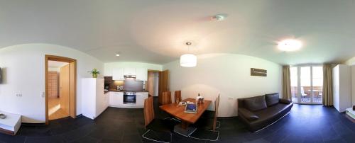 a kitchen and living room with a table and a couch at Apart Mountain Lodge Mayrhofen in Mayrhofen