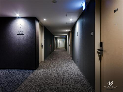 a corridor of a hallway with black walls and a corridorngthngthngth at Daiwa Roynet Hotel Matsuyama in Matsuyama