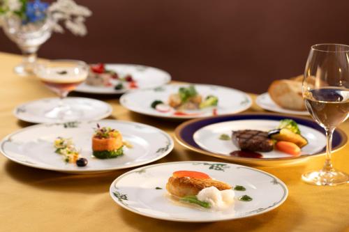 a table with plates of food and a glass of wine at Mampei Hotel in Karuizawa