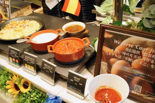 a display with pots and pans of food on a shelf at Hotel Monterey Akasaka in Tokyo