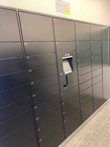 a row of lockers in an airport with a pay phone at 902 6名様宿泊可能 札幌中心部 すすきの駅より徒歩5分 ロケーション最高 in Sapporo