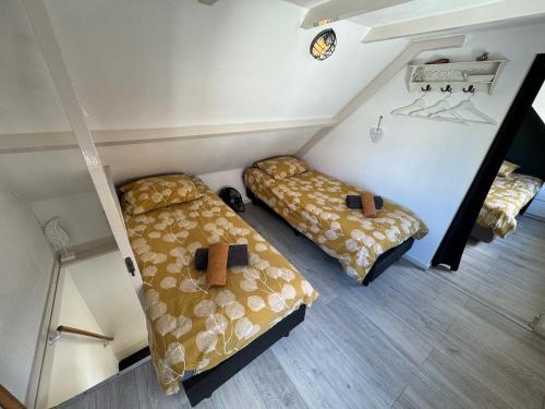 a room with two beds in a room at Vakantiehuisje aan Zee - 100m van Strand in Egmond aan Zee