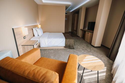 a hotel room with a bed and a couch at Хотел Панорама in Pleven