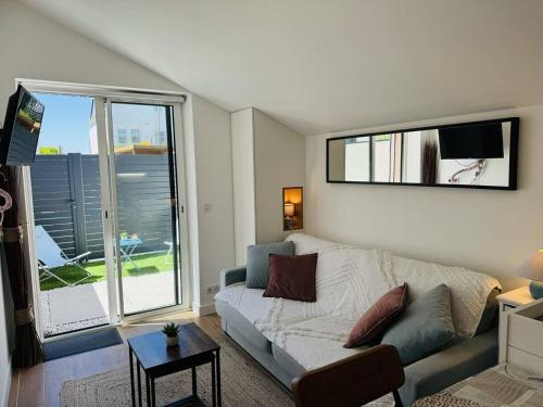 un salon avec un canapé et une grande fenêtre dans l'établissement Studio Téviec, 50m plage, parking, wifi, à Penthièvre