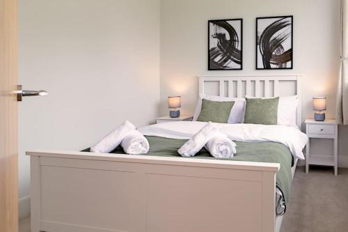 a bedroom with a large white bed with towels on it at Beechwood House in Melton Mowbray