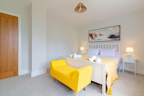a bedroom with a bed and a yellow chair at Beechwood House in Melton Mowbray