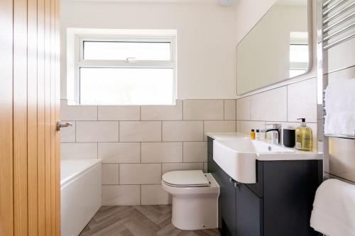 a white bathroom with a sink and a toilet at Beechwood House in Melton Mowbray