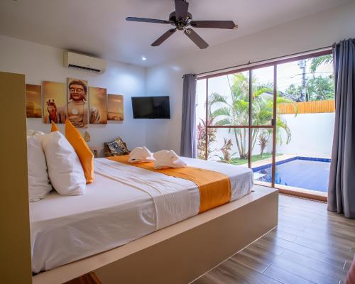 a bedroom with a large bed and a large window at Bali Villas Panglao Bohol in Panglao