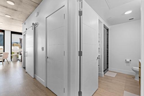 a hallway with white cabinets and a bathroom at Downtown views! Amazing pool gym hottub Luxury apt in Salt Lake City