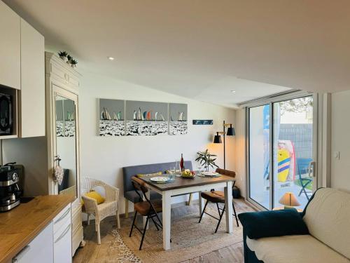 une cuisine et un salon avec une table et un canapé dans l'établissement Studio Ty Cool, jardin 200m carré, 50m plage, wifi, parking, à Penthièvre
