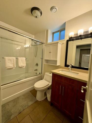 a bathroom with a toilet and a shower and a sink at Cozy 1BR Near Skytrain - Explore Vancouver Easily in Vancouver