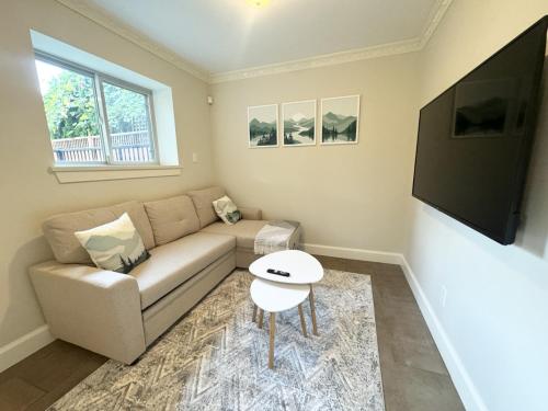 a living room with a couch and a flat screen tv at Cozy 1BR Near Skytrain - Explore Vancouver Easily in Vancouver