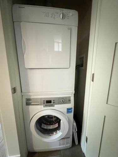 a washer and dryer in a small room at Cozy 1BR Near Skytrain - Explore Vancouver Easily in Vancouver
