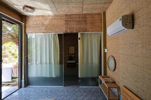 a room with a glass door and a heater at Hành Ngò Homestay - Hòn Đỏ Ninh Thuận in Thôn Dư Khánh