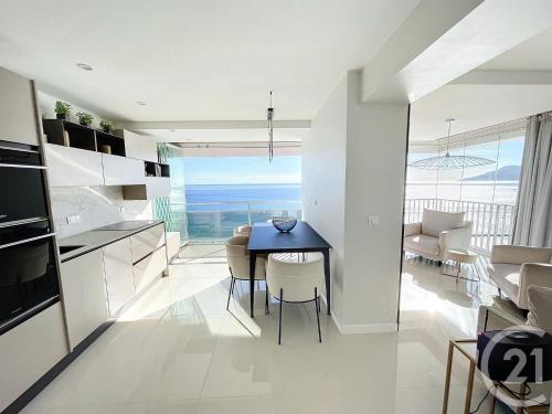 une cuisine et une salle à manger avec une table et des chaises dans l'établissement Vue mer exceptionnelle - Appartement Deluxe, à Cannes