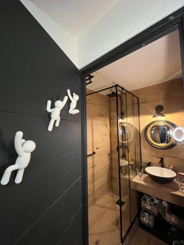 a bathroom with a shower with white people on the wall at Appartement ambiance chalet Avoriaz in Avoriaz