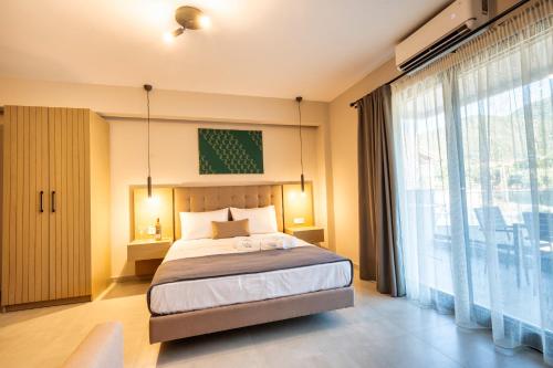 a bedroom with a bed and a large window at Lofos Luxury Living in Stavros