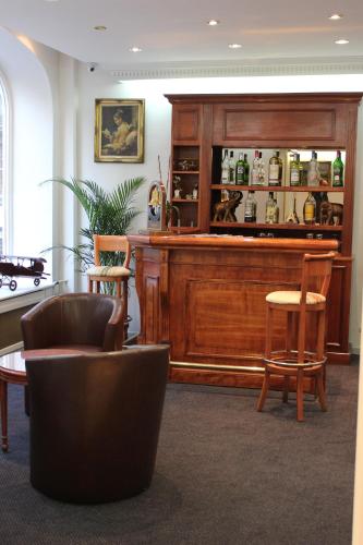 - un hall avec un bar avec deux chaises et une table dans l'établissement Metropol, à Paris