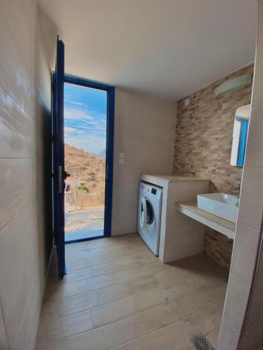 a laundry room with a washing machine and a sink at Emborios Views - Holiday House in Kalymnos