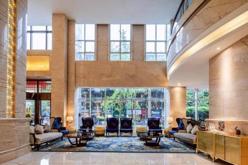 a lobby with couches and chairs in a building at Chengdu Rising Butterfly Hotel in Chengdu